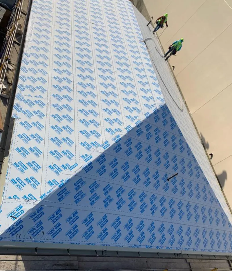 Professional roofers installing underlayment on a metal roof in Mahtomedi